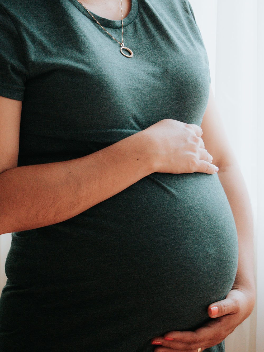 image of pregnant woman holding her belly before prenatal massage